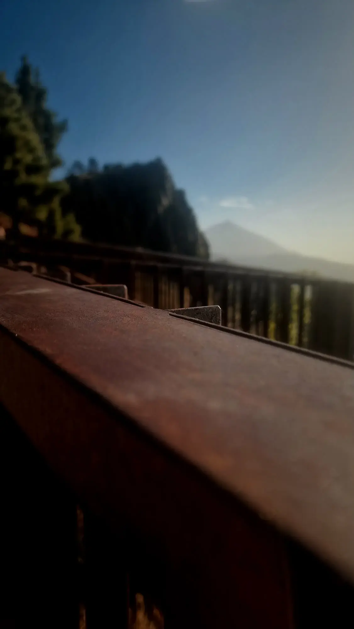 Barandilla de un mirador con la montaña al fondo y cielo azul