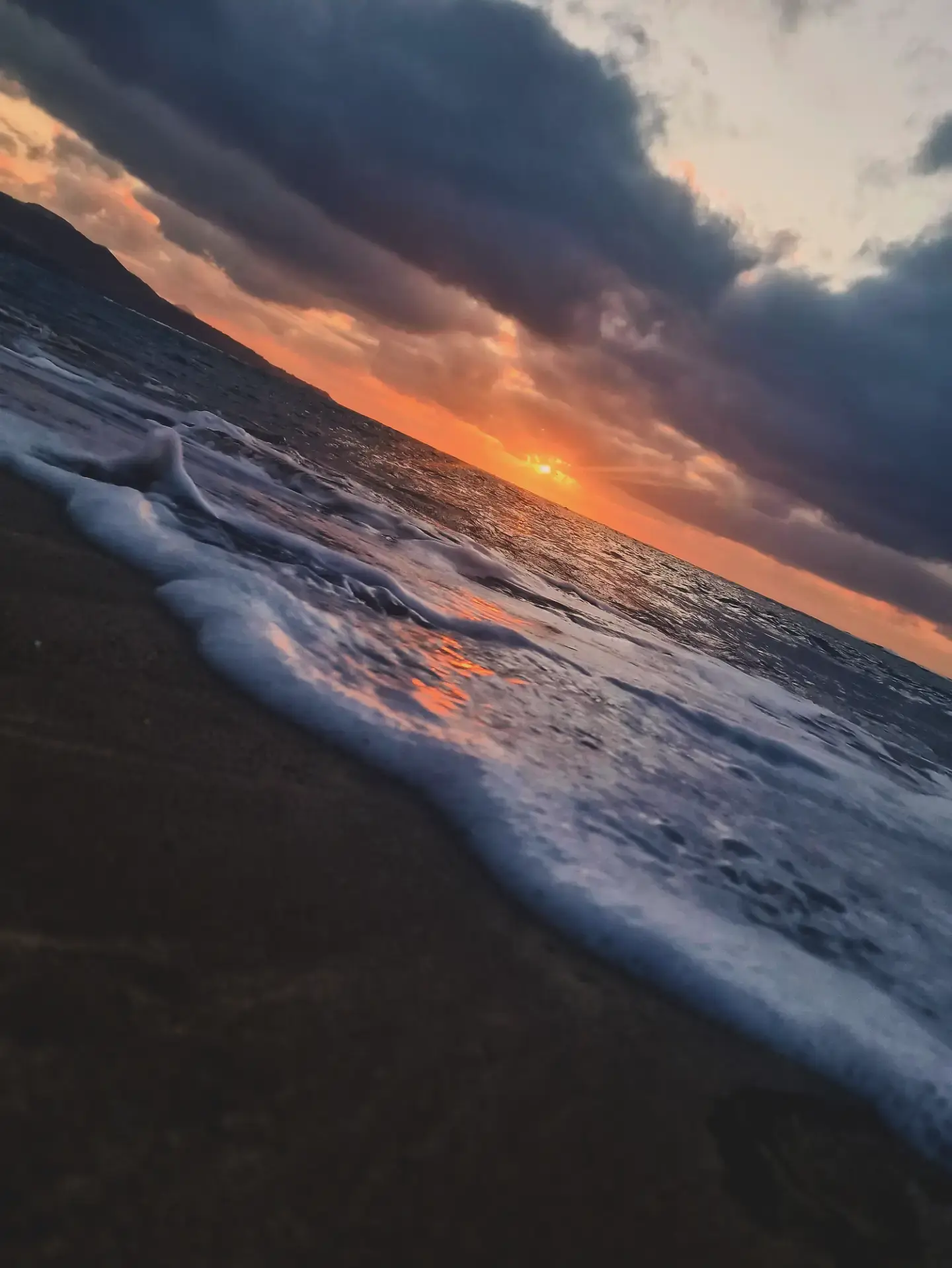 Olas en la orilla de una playa bajo un cielo de atardecer