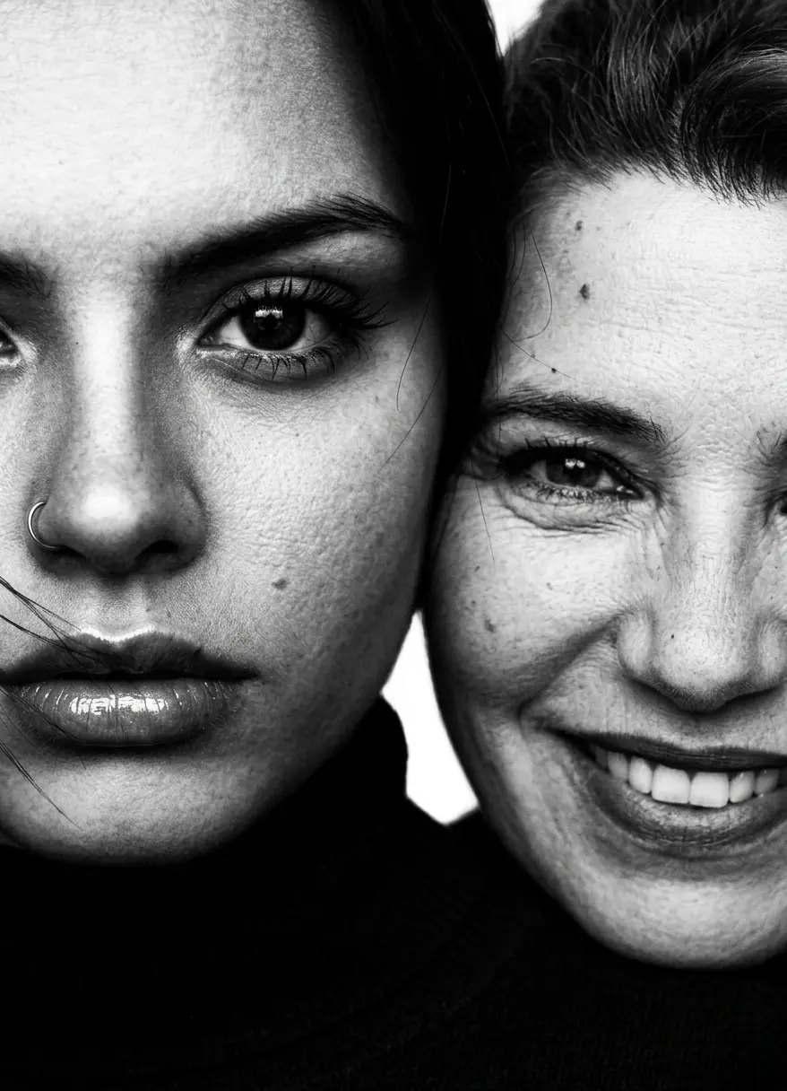 Dos mujeres mejilla con mejilla, una seria y otra sonriendo, blanco y negro